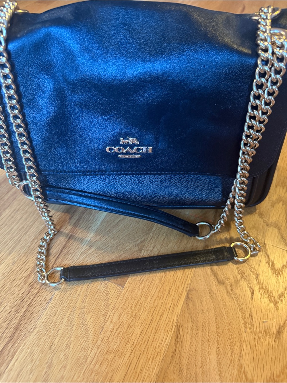 Black logo Coach shoulder bag with gold tone and leather strap.